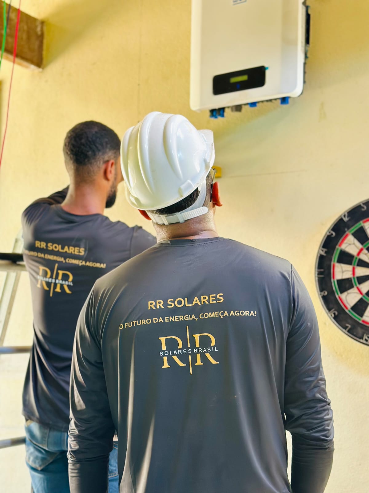 Inversor WEG instalado e uniforme da RR Solares com o slogan O futuro da energia, começa agora