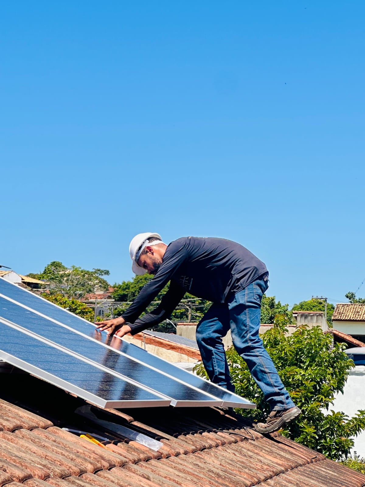 Técnico fixando e alinhando placas solares no telhado